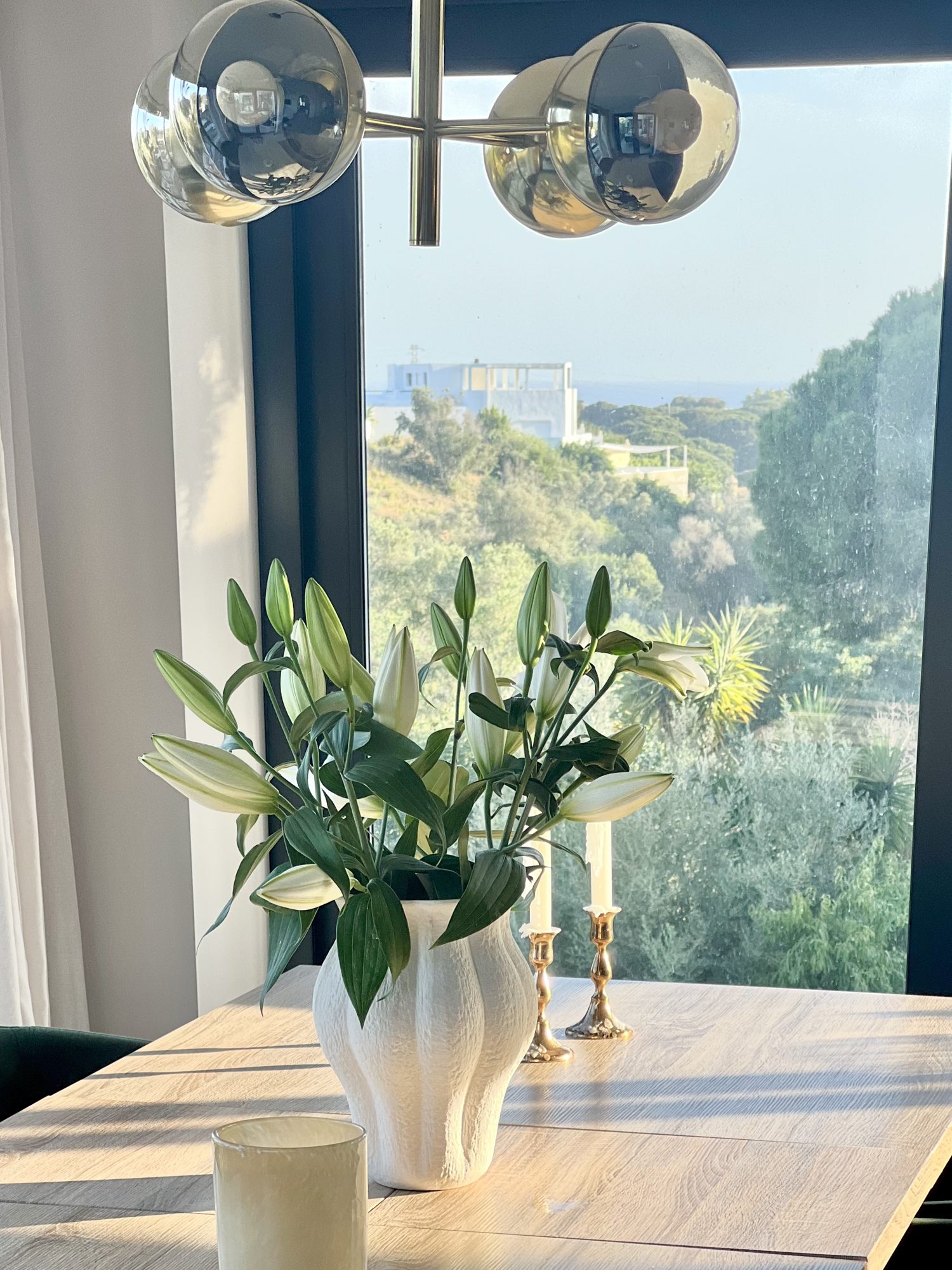 Ricmar — Dining — a seaview window left uncluttered, the table drawn around it.