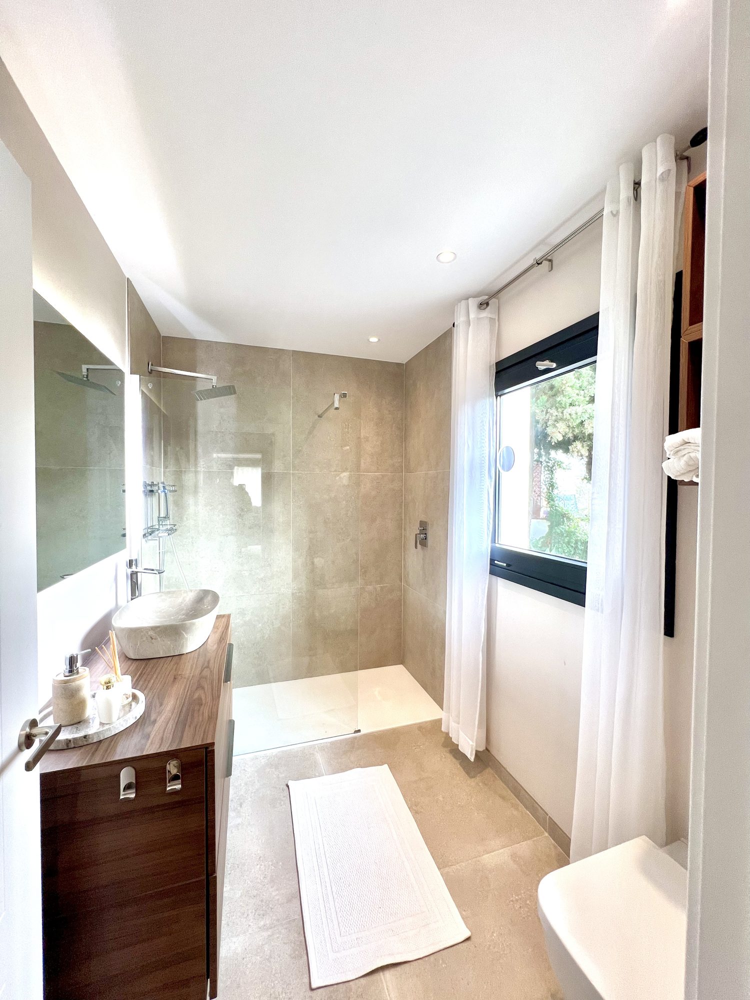 Ricmar — En-suite — stone basin, warm metal, natural light.
